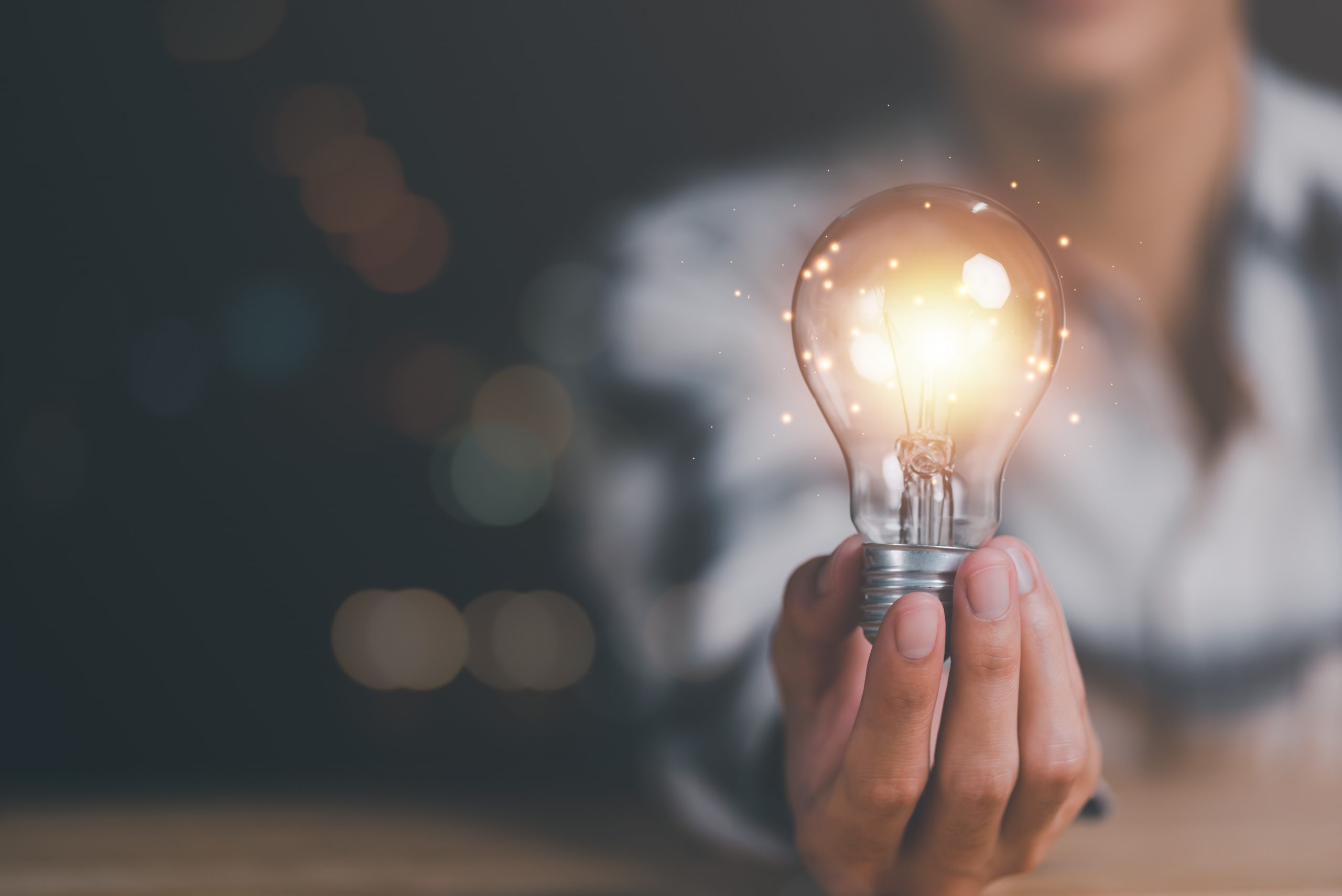 solution concept and demonstrating leadership strategies,that lead the business in a successful direction,with innovation and brain power from brainstorming,light bulb in human hand