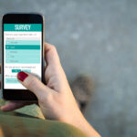 Woman walking and filling online survey form with a smartphone